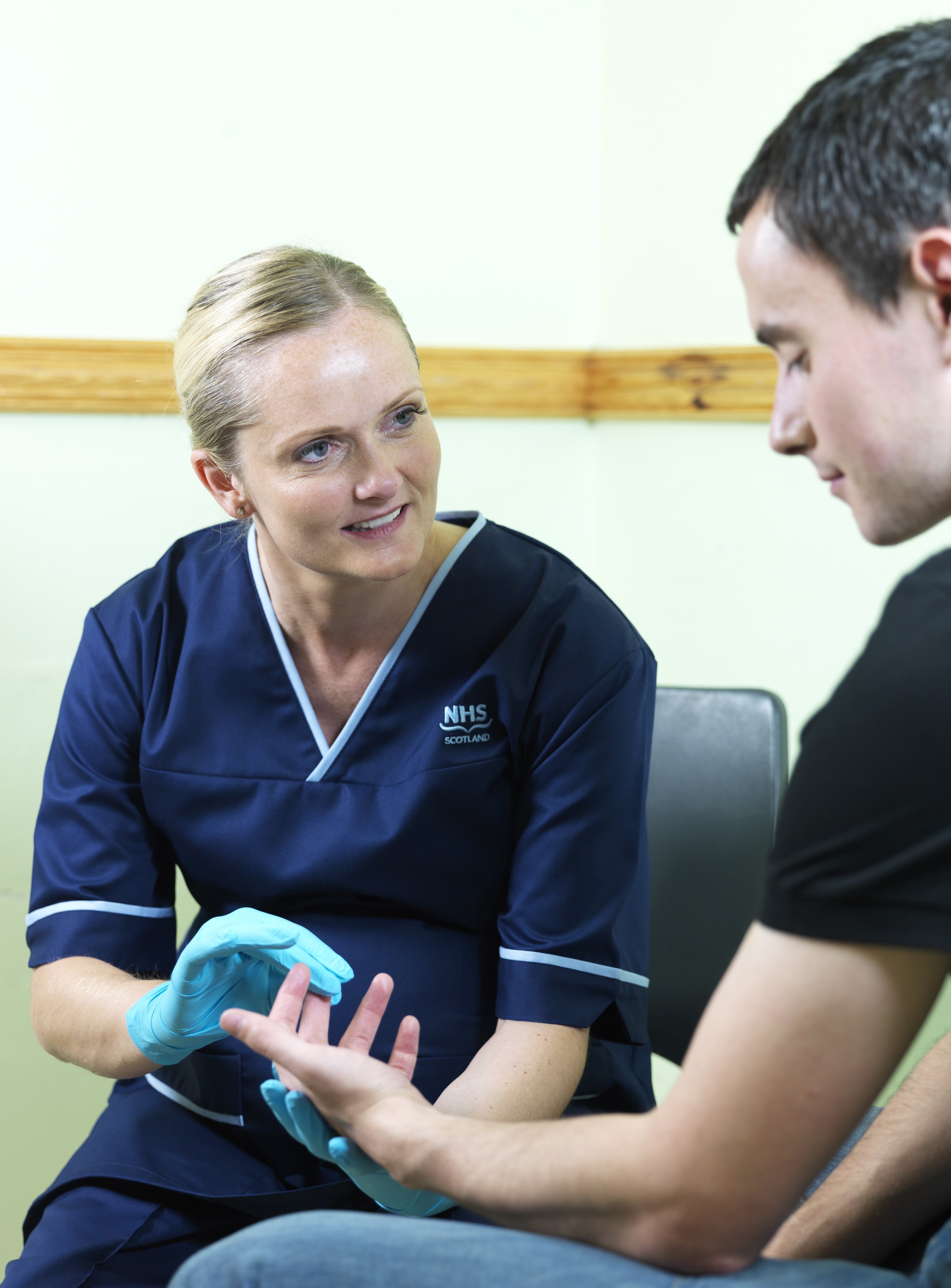 An NHS Scotland staff member treating a patient.